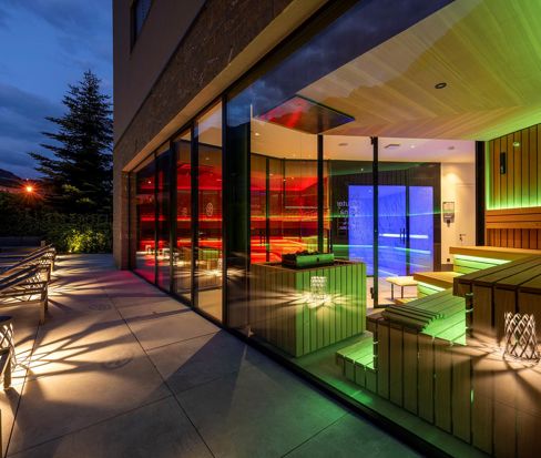 Saunaoase am Abend mit beleuchteter Glasfront