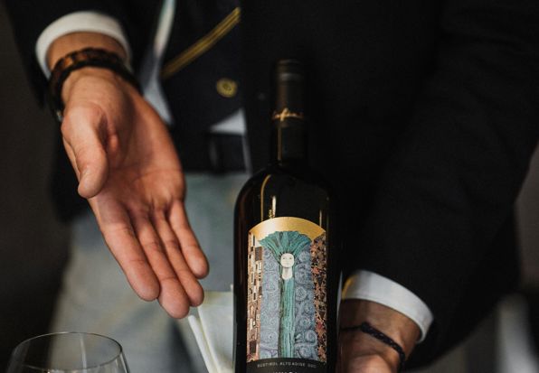 A waiter presents a bottle of wine